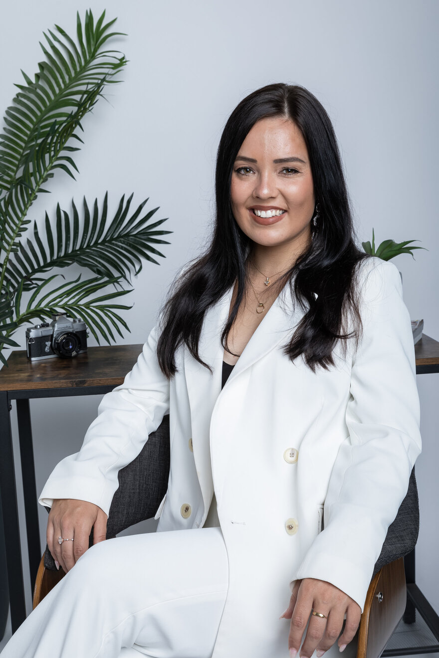 Dr. Alena Schuss sitting in chair next to plant